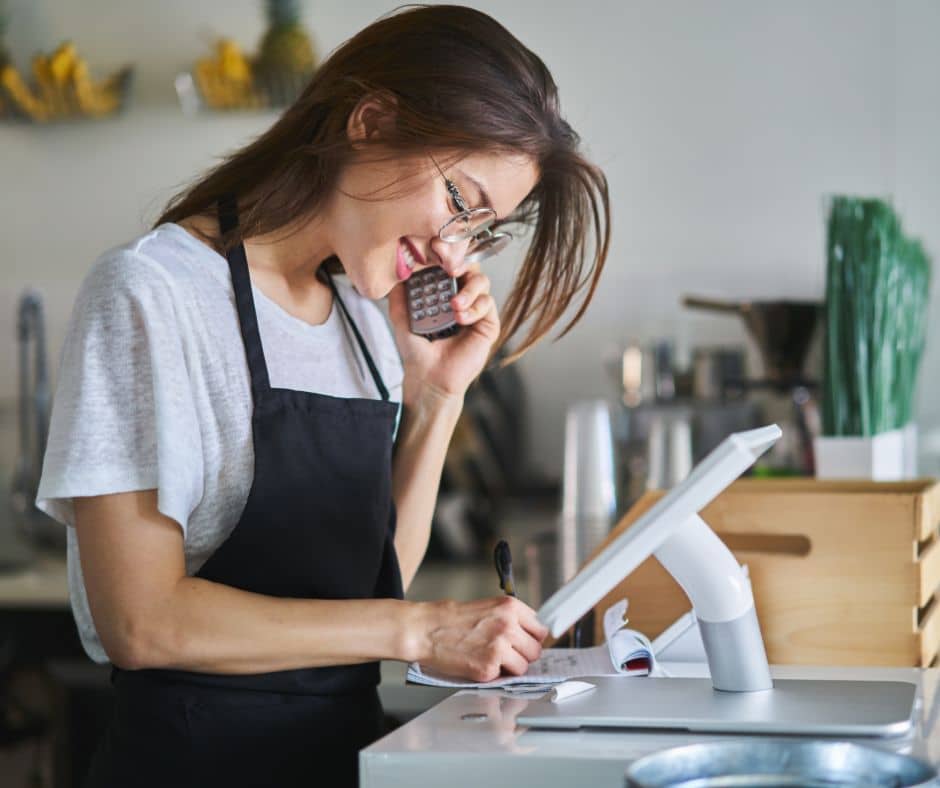 woman talking on the phone in front of her pos system
